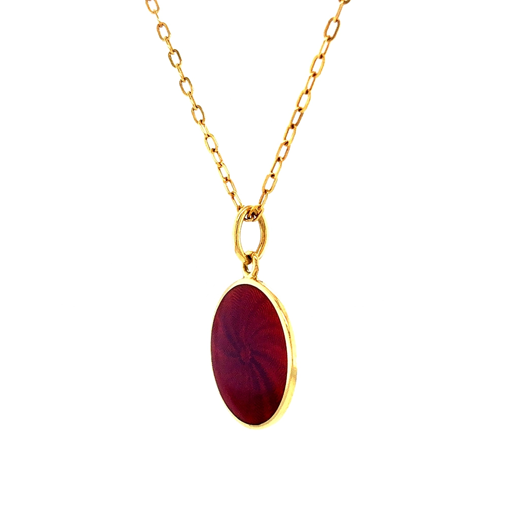 Kleiner runder Anhänger aus Gelbgold, etwa so groß wie eine kleine Münze. Die Vorderseite schimmert in opalisierendem Himbeer, das im Licht wie ein Opal die Farben changieren lässt. Ein feines Wellenmuster wird unter der Emaille sichtbar.