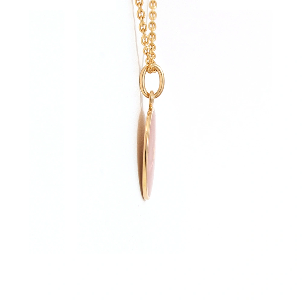 Kleiner runder Anhänger aus Gelbgold, etwa so groß wie eine kleine Münze. Die Vorderseite schimmert in transluzider rosafarbener Emaille mit feinem Wellenmuster. In der Mitte liegt ein winziges sechseckiges Goldplättchen in Sternform mit mikroskopisch feinen Reliefdetails.