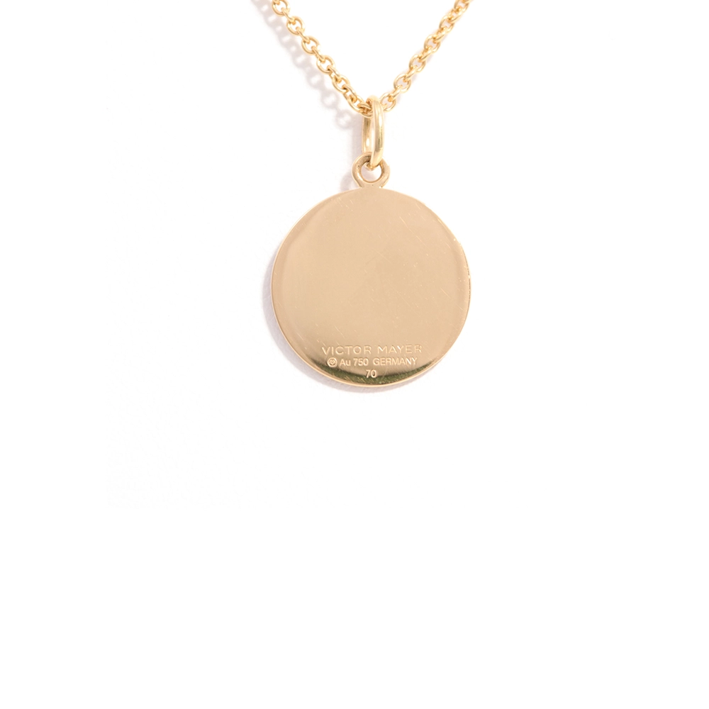 Kleiner runder Anhänger aus Gelbgold, etwa so groß wie eine kleine Münze. Die Vorderseite schimmert in transluzider rosafarbener Emaille mit feinem Wellenmuster. In der Mitte liegt ein winziges sechseckiges Goldplättchen in Sternform mit mikroskopisch feinen Reliefdetails.