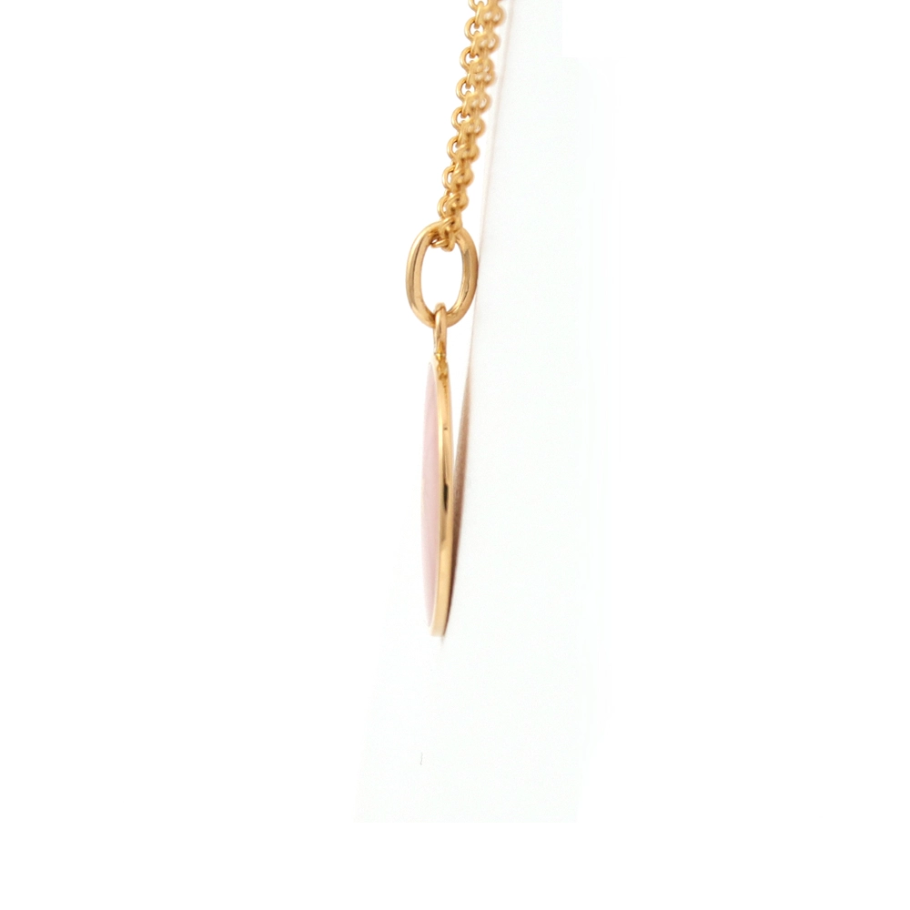 Kleiner runder Anhänger aus Gelbgold, etwa so groß wie eine kleine Münze. Die Vorderseite schimmert in transluzider rosafarbener Emaille mit feinem Wellenmuster. In der Mitte liegt ein winziges sechseckiges Goldplättchen in Sternform mit mikroskopisch feinen Reliefdetails.