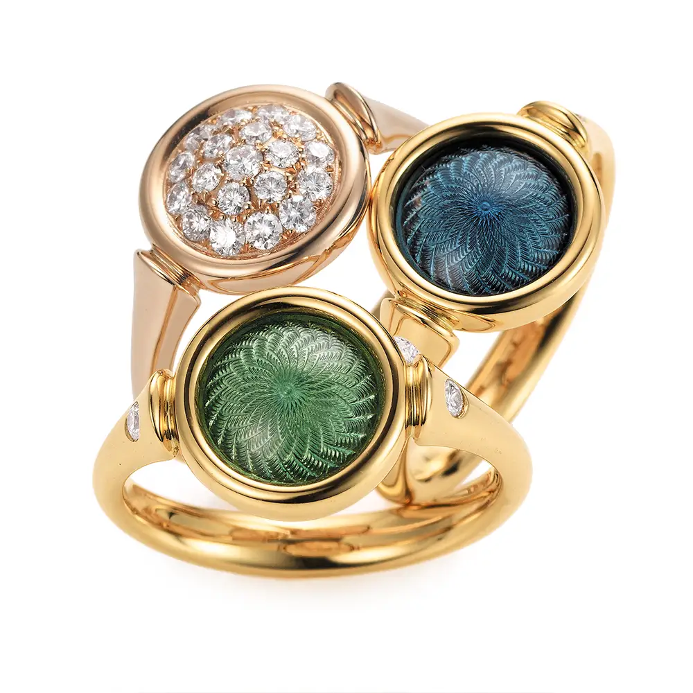 Schmuckset Candy bestehend aus zwei Ringen in Gelbgold mit rundem, leicht gewölbtem Kopf, mediumblauem und helltürkisfarbenem Emaille in Windmühlenmuster und einem Ring in Roségold mit Diamantpavé
