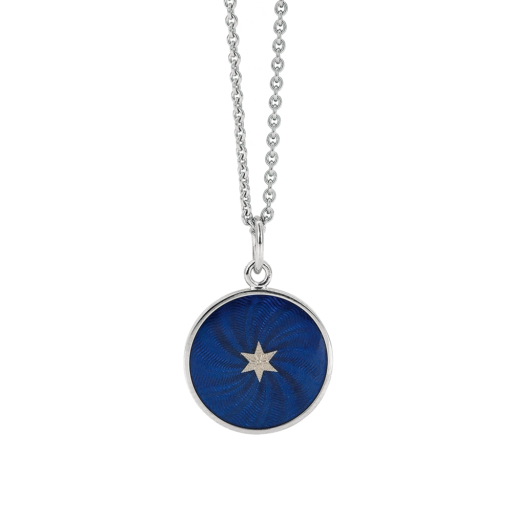 Kleiner runder Anhänger aus Weißgold, etwa so groß wie eine kleine Münze. Die Vorderseite schimmert in transluzider Electric blue Emaille mit feinem Wellenmuster. In der Mitte liegt ein winziges sechseckiges Goldplättchen in Sternform mit mikroskopisch feinen Reliefdetails.