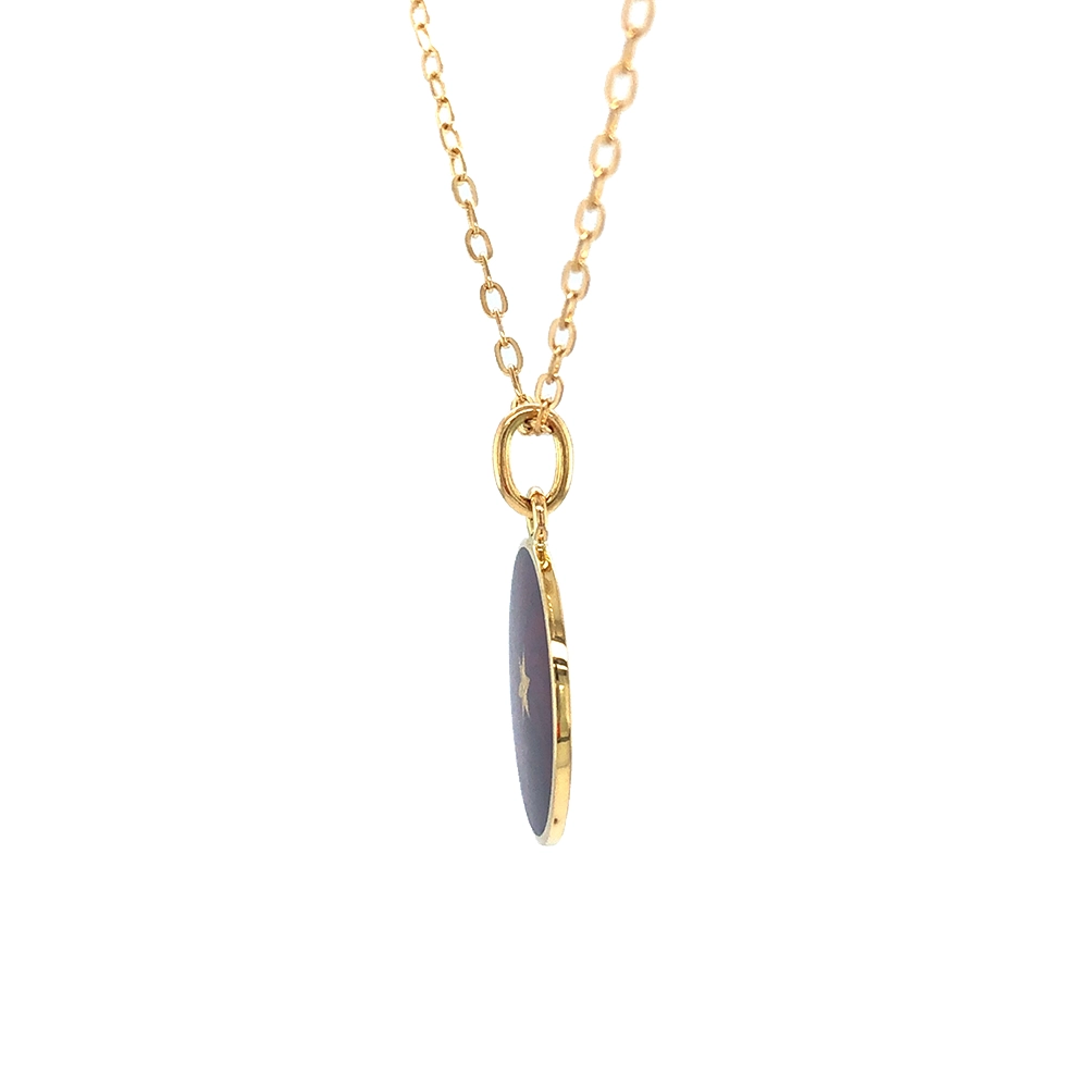 Kleiner runder Anhänger aus Gelbgold, etwa so groß wie eine kleine Münze. Die Vorderseite schimmert in transluzider auberginefarbener Emaille mit feinem Wellenmuster. In der Mitte liegt ein winziges sechseckiges Goldplättchen in Sternform mit mikroskopisch feinen Reliefdetails.