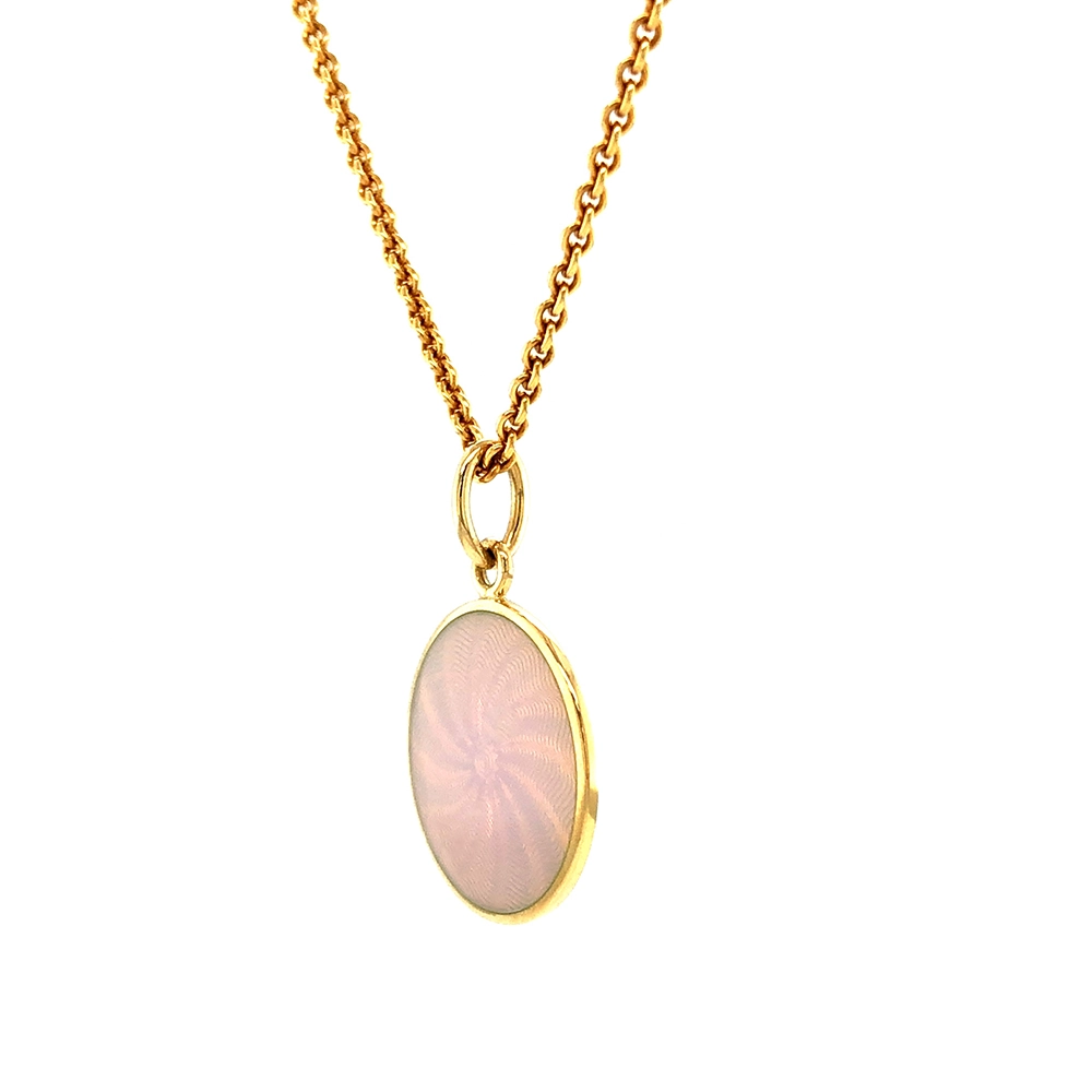 Kleiner runder Anhänger aus Gelbgold, etwa so groß wie eine kleine Münze. Die Vorderseite schimmert in opalisierendem Weiß, das im Licht wie ein Opal die Farben changieren lässt. Ein feines Wellenmuster wird unter der Emaille sichtbar.