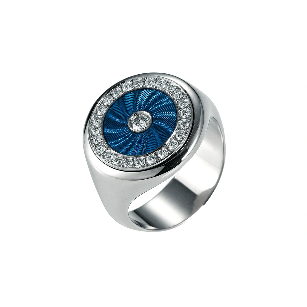 Eleganter runder Ring aus Weißgold mit transluzider hellblauer Emaille und feinem Wellenmuster. Das Inlay ist von 25 funkelnden Brillanten eingefasst. Die Ringschiene ist unterhalb des Ringkopfes tailliert und auf der Unterseite verbreitert, was Komfort und eine markante Form verleiht.