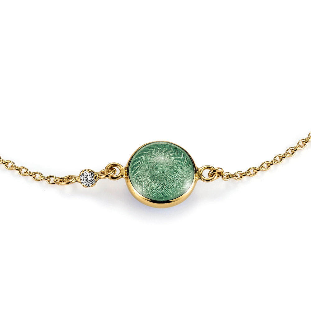 Candy bracelet in yellow gold featuring a double-sided, round, slightly domed central enamel element in translucent light green vitreous enamel over fine windmill guilloché, a sparkling diamond set into the anchor chain, and a guilloché hexagonal tag at the clasp, diameter 20.2 mm, length 19 cm.