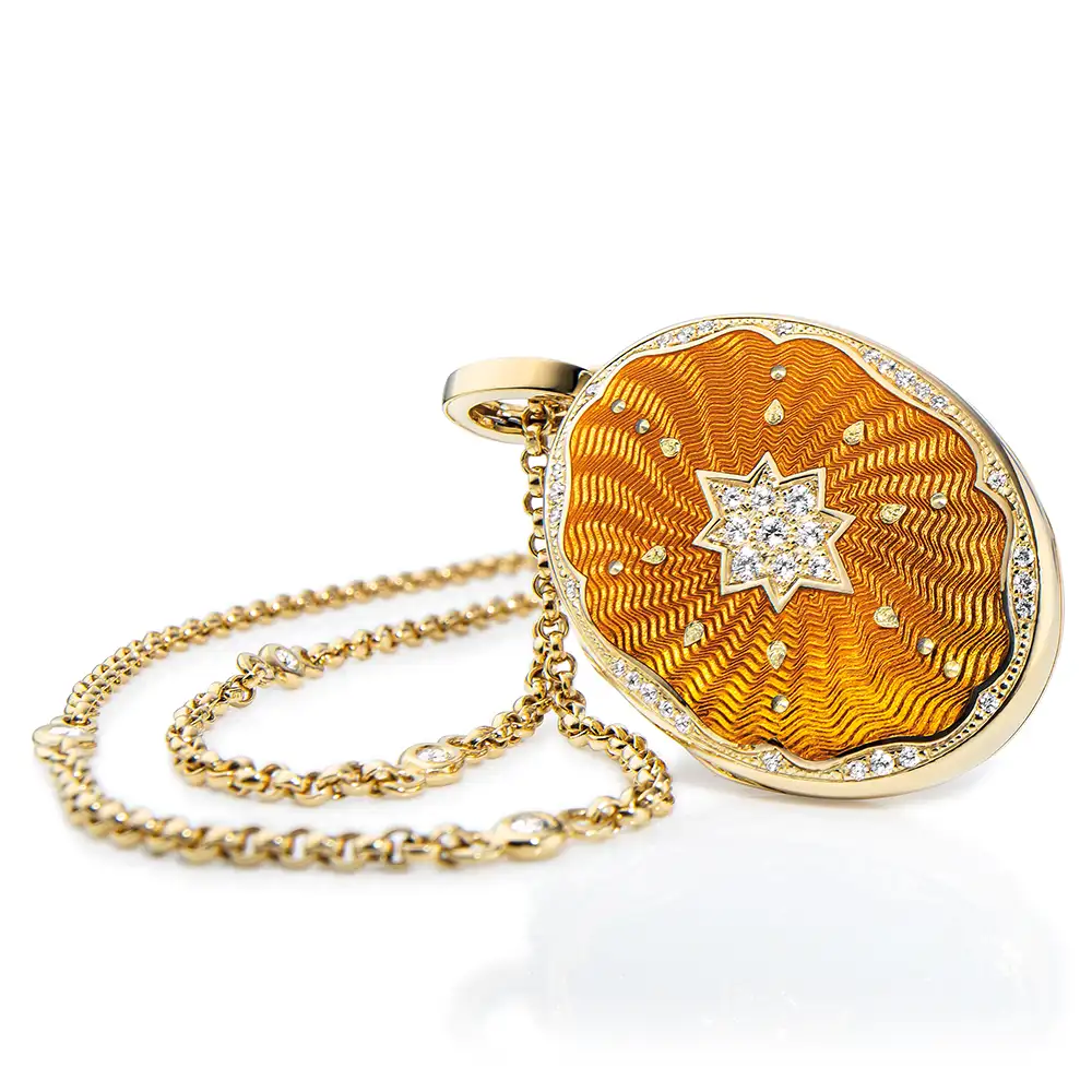 Ovaler Medaillon-Anhänger aus Gelbgold, gelb lackiert mit einer vielzahl kleiner goldener Punkte und mit einem Stern aus Brillanten in der Mitte.