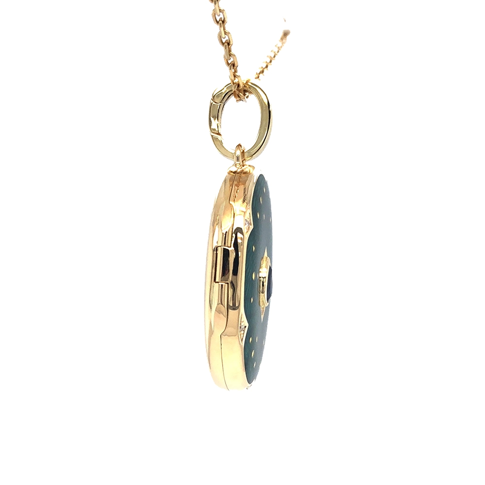 Ovaler Medaillon-Anhänger aus Gelbgold, grün lackiert mit zahlreichen kleinen Goldpunkten und mit einem tropfenförmigen blauen Edelstein in der Mitte.