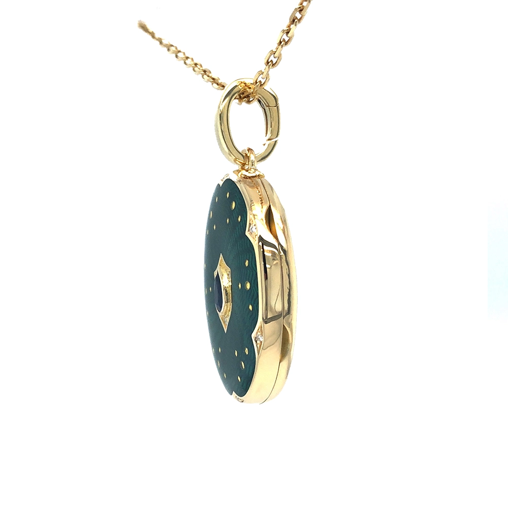 Ovaler Medaillon-Anhänger aus Gelbgold, grün lackiert mit zahlreichen kleinen Goldpunkten und mit einem tropfenförmigen blauen Edelstein in der Mitte.