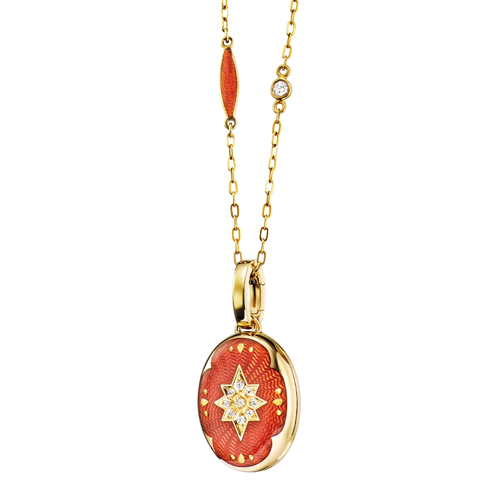 Ovaler Medaillon-Anhänger aus Gelbgold, rot lackiert mit einer vielzahl kleiner goldener Punkte und mit einem Stern aus Brillanten in der Mitte.